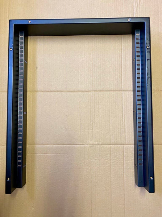A black metal mounting frame or bracket with pre-drilled screw holes and textured inner slots, shown against a light brown corrugated cardboard background.