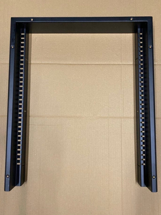 A black metal mounting bracket or frame with two vertical arms and a horizontal top bar, photographed against a tan cardboard background.
