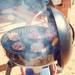 Cadac Carri Chef 40 - BBQ & Chef Pan Combo lifestyle image of BBQ with Lid as windshield and grilling 4 burgers and some red and yellow peppers near the lid with half an onion on a table and chopping board in the background. Smoke engulfs the grill 