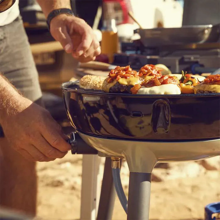 Cadac Carri Chef 40 QR BBQ, Paella Pan & Grill Combo - lifestyle image, showing BBQ being used to cook food