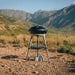 Cadac Carri Chef 40 QR BBQ, Paella Pan & Grill Combo - lifestyle image, showing BBQ connected to small gas canisters with lid closed