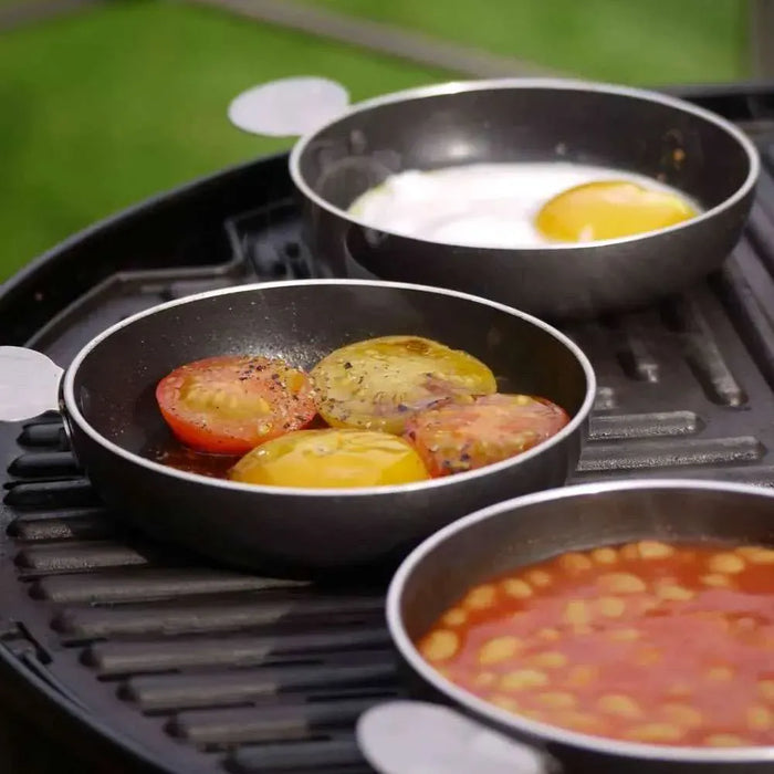 Cadac Tapas Dishes - Set of 4 - lifestyle image, showing three tapas dishes being used to cook egg, tomatoes, and beans on camping barbecue