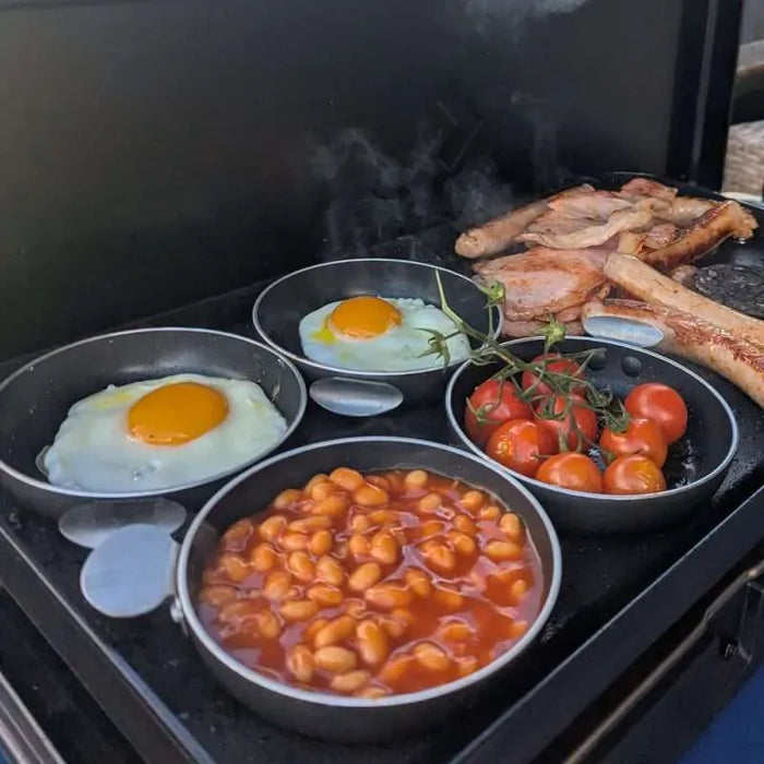Cadac Tapas Dishes - Set of 4 - lifestyle image, showing tapas dishes being used to cook eggs, beans, and tomatoes on stove