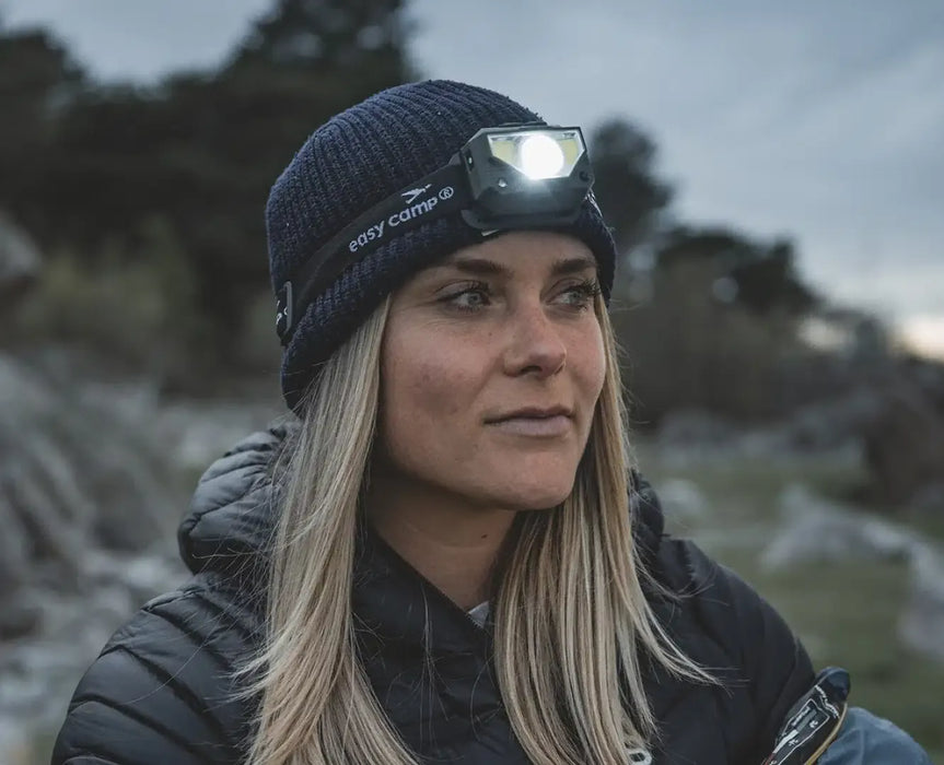 Easy Camp Crowberry Rechargeable Head Torch - lifestyle image, showing person wearing lit head torch