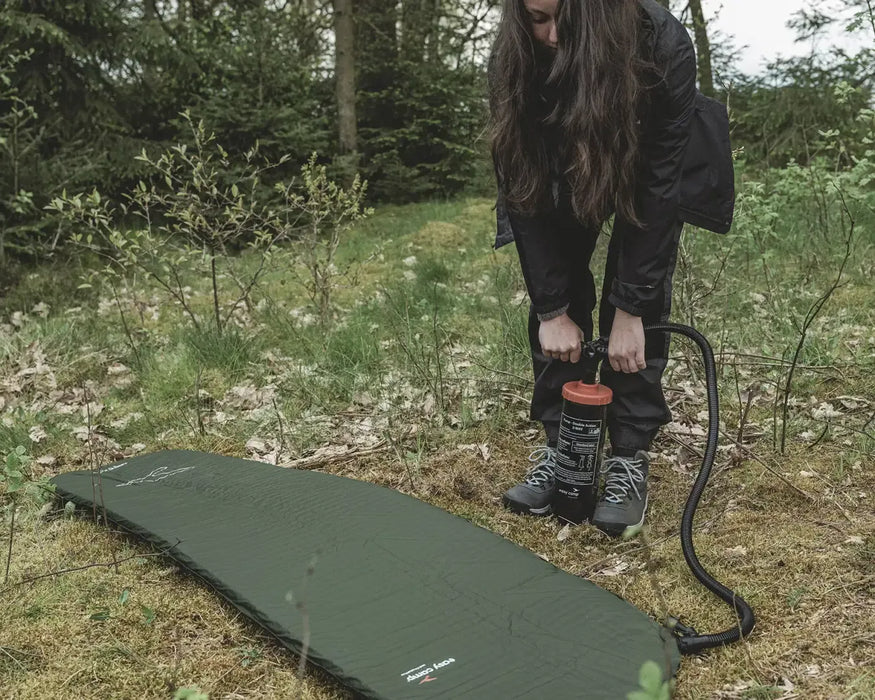Easy Camp Double Action Manual Air Pump - lifestyle image, showing person using pump to inflate camping mattress