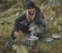 Easy Camp Moss 4 Person Camping Cook Set - product image, showing person using pot on top of camping stove, with mug, plate, and pan