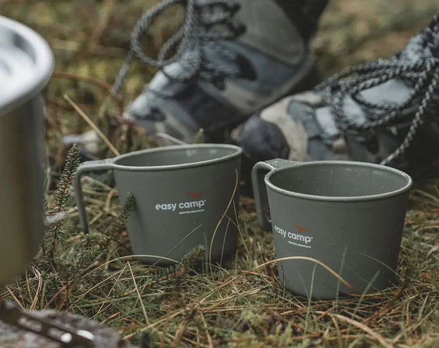Easy Camp Moss 4 Person Camping Cook Set - product image, showing close-up of mugs in front of person's feet