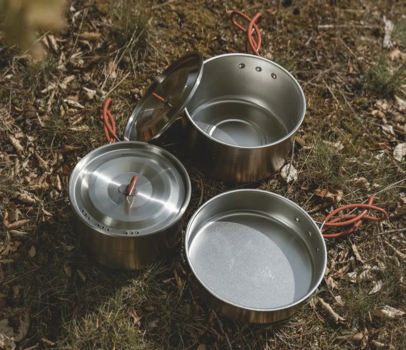 Easy Camp Moss Tour Stainless Steel Cook Set - lifestyle image, showing bird's eye view of set components (2x pots with lids, 1x pan) outside on ground