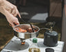 Easy Camp Moss Tour Stainless Steel Cook Set - lifestyle image, showing close-up of person using pan with spatula (not included) to cook over camping stove