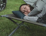 Easy Camp Raven Compact Camping Travel Pillow - lifestyle image, showing person lying on camp bed with pillow