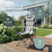 Leisurewize High Back Padded Folding Camping Chair with Cup Holder - lifestyle image, showing chair positioned on decking in garden area with greenery in foreground and house in background