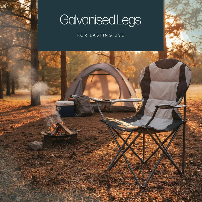 Leisurewize High Back Padded Folding Camping Chair with Cup Holder - lifestyle image, showing chair in foreground positioned on ground in woodland with tent and small fire positioned behind to the left
