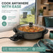 Leisurewize Multi-Functional Electric Skillet / Cooker 1500W - product infographic, showing a portable electric skillet with a clear lid sitting on a wooden table inside a camper or caravan, with a cooked food dish visible inside the pan. Large marketing text on the left highlights 1500W power and rapid cooling, and a green banner at the bottom mentions camping, caravans, motorhomes, and student living.