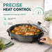 Leisurewize Multi-Functional Electric Skillet / Cooker 1500W - product infographic, showing an electric skillet with a glass lid, filled with cooked chicken and vegetables, on a marble countertop. A hand is turning the control knob on the side.