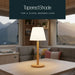 Leisurewize Orli Rechargeable Table Lamp – product image, showing an illuminated table lamp on a wooden table inside a caravan, with caption demonstrating 'Tapered Shade'