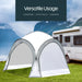 Leisurewize Outdoor Retreat Quick Erect Camping Shelter 3.5m - product infographic showing white and gray pop-up car camping shelter tent pitched on green grass next to a white motorhome, with a dark teal text banner at the top reading 'Versatile Usage' and 'Camping - Festivals - Garden'.
