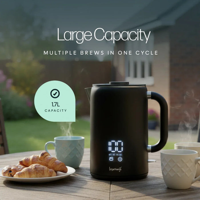 Leisurewize Sleek LED Kettle Black 1.7L 1000W - product image, showing a large black electric kettle with a digital display sits on a wooden table outdoors, with coffee mugs and croissants nearby. Text on the image highlights 'Large Capacity' and '1.