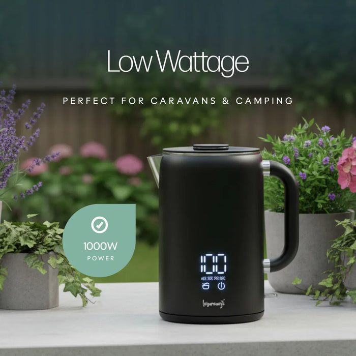 Leisurewize Sleek LED Kettle Black 1.7L 1000W - product image, showing a black electric kettle on a outdoor surface surrounded by potted plants, with garden scenery in the background, with text above: 'Low Wattage - perfect for caravans & camping'