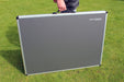 Grey folding table with carrying handle on a grassy background