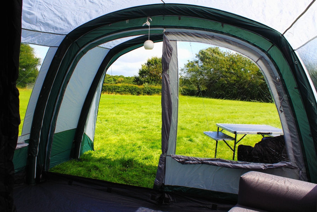 Outdoor Revolution Atom 500 - product image showing tent interior with front door open, taken from inside the tent, with furniture and hanging light inside tent, and visible outside view of field and surrounding trees