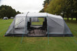 Outdoor Revolution Camp Star 500 DT- Poled 5-Berth Tunnel Tent Bundle feature image of the tent pitched on a green grassy campsite. right side view with the side door open, all curtains open and a carpet table and chairs in the tent