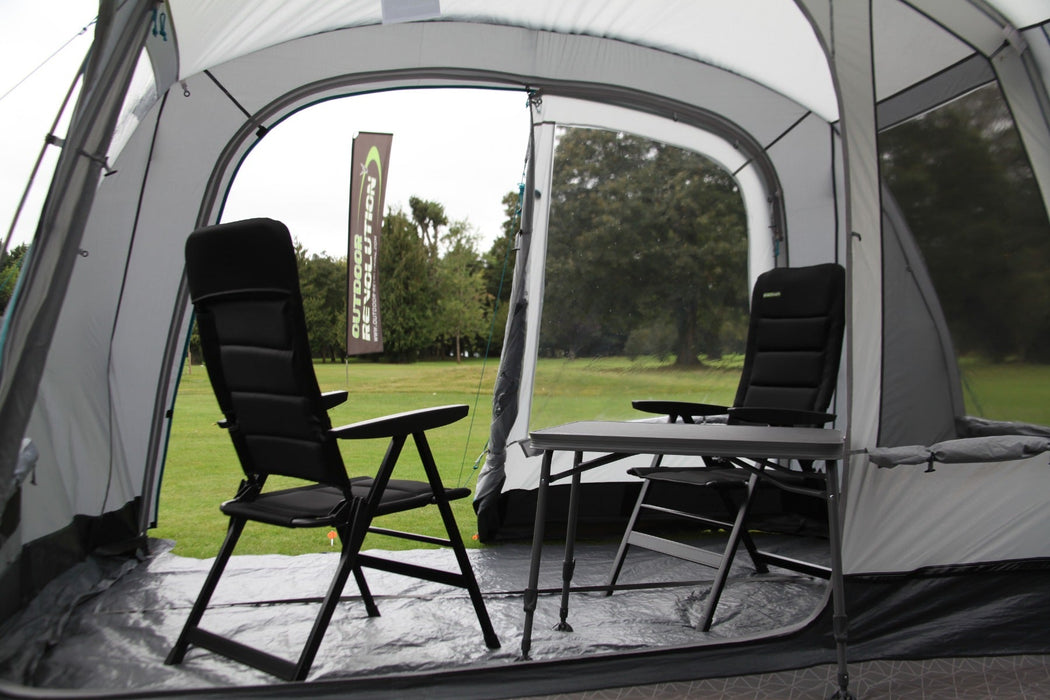 Outdoor Revolution Camp Star 500 DT- Poled 5-Berth Tunnel Tent Bundle feature image of the tent pitched on a green grassy campsite. view from inside the tent with table and chairs in porch area. Outdoor revolution flag on the grass in front of tent