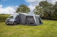 orda1623-01 Van with a large outdoor inflatable awning set up on a grassy area with trees in the background.