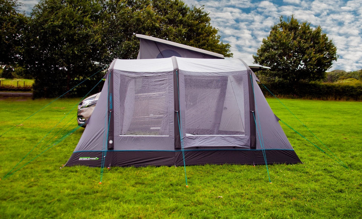 Camping tent with attached air bed on a grassy field