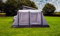 Camping tent with attached air bed on a grassy field