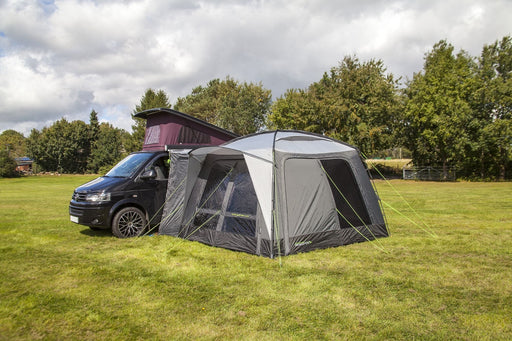 orda1640 Outdoor Revolution Cayman DT Awning attached to van with a large in a grassy field with trees in the background