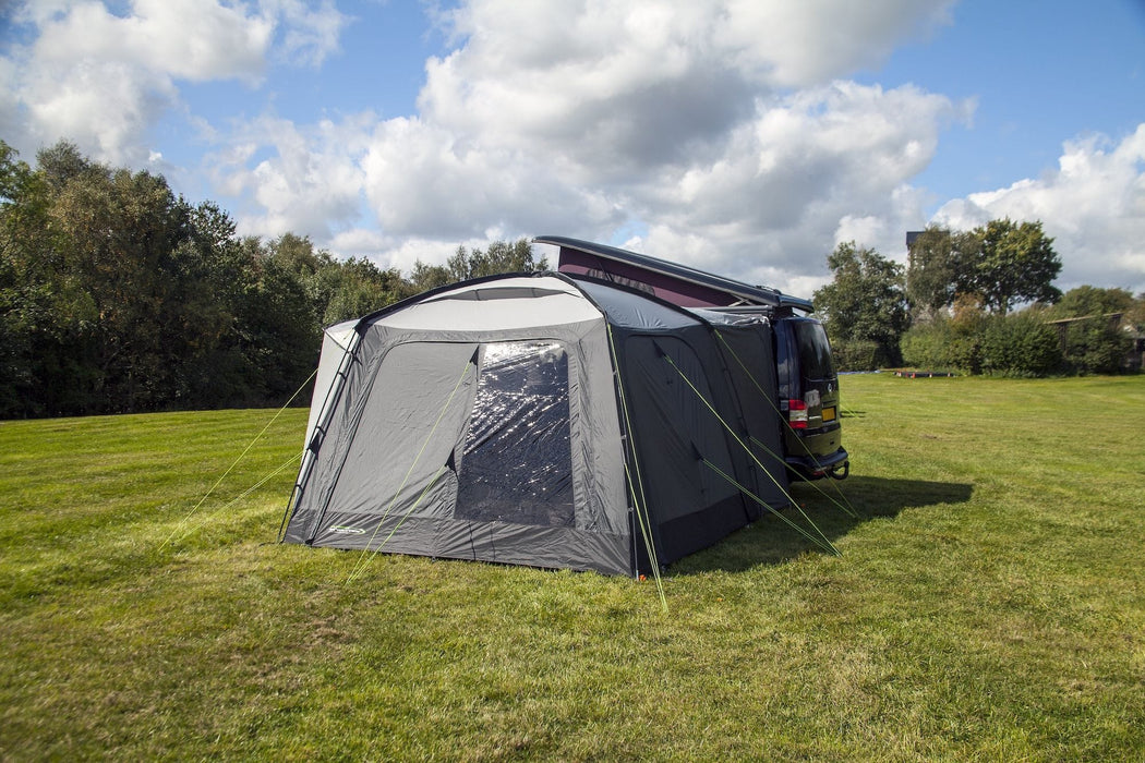 orda1640 Outdoor Revolution Cayman DT Awning attached to van with a large in a grassy field with trees in the background rear view
