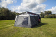 orda1640 Outdoor Revolution Cayman DT Awning attached to van with a large in a grassy field with trees in the background rear view