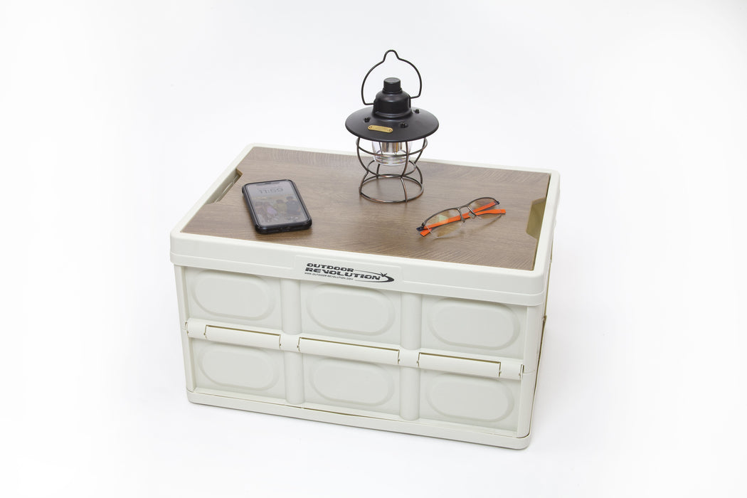 Outdoor Revolution Shimanto Folding Camping Storage Box with Table Top - product image, showing expanded storage box with table top included, with mobile phone, lamp, and glasses on top