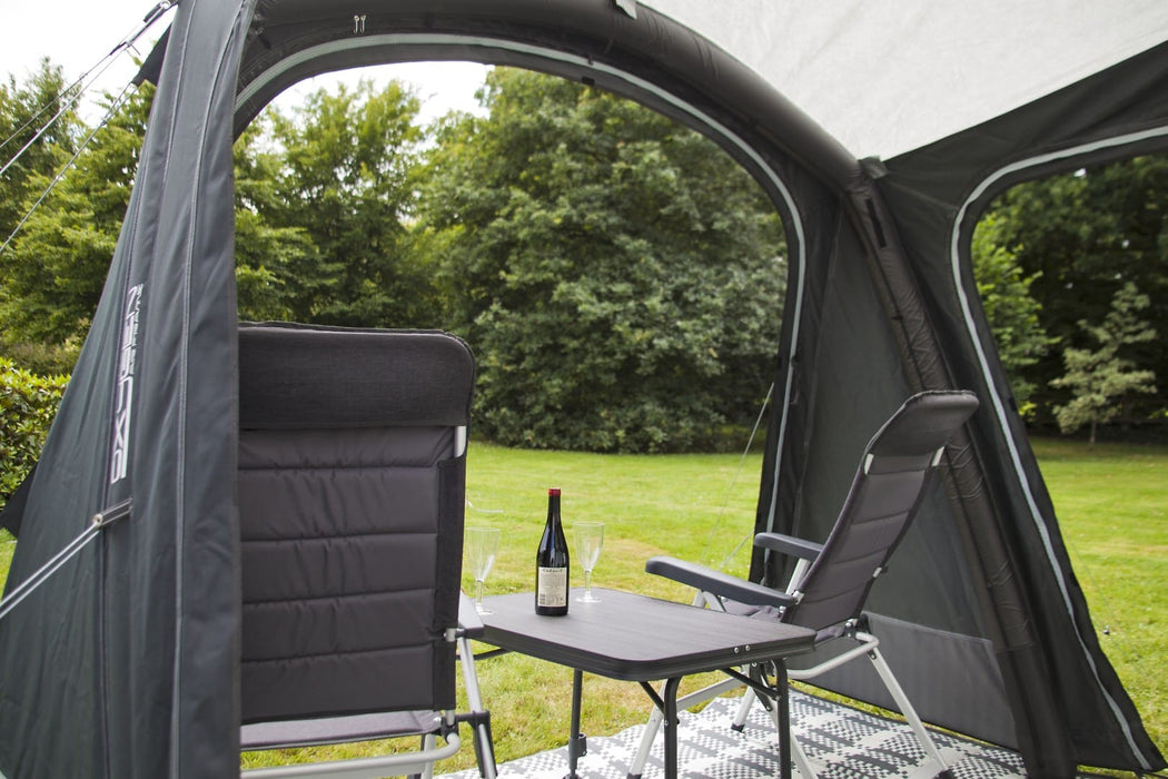 Outdoor Revolution Sport Pro 260 Inflatable Air Canopy with Front Door lifestyle image with bottle of wine chairs and table