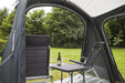 Outdoor Revolution Sport Pro 260 Inflatable Air Canopy with Front Door lifestyle image with bottle of wine chairs and table