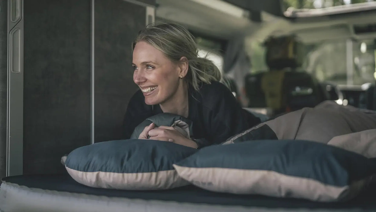 Outwell Comfort Deluxe Large Camping Pillow - lifestyle image, showing person in sleeping bag laying in sleeping bag with pillow