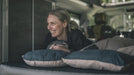 Outwell Comfort Deluxe Large Camping Pillow - lifestyle image, showing person in sleeping bag laying in sleeping bag with pillow