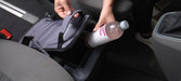 Outwell Eagle Van Cooler 15 Litre Camping Cool Bag - lifestyle image, showing person putting bottle into cool bag placed between seats inside a vehicle