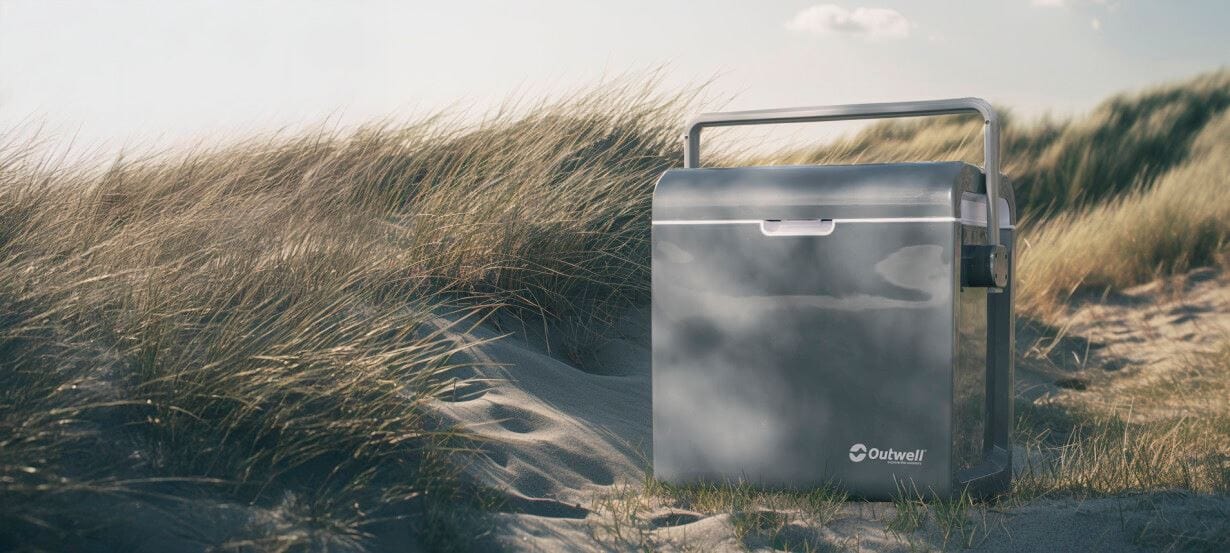 Outwell ECOcool 24L Cool Box 12V/230V – Slate Grey - lifestyle image, showing product outdoors on sand dune