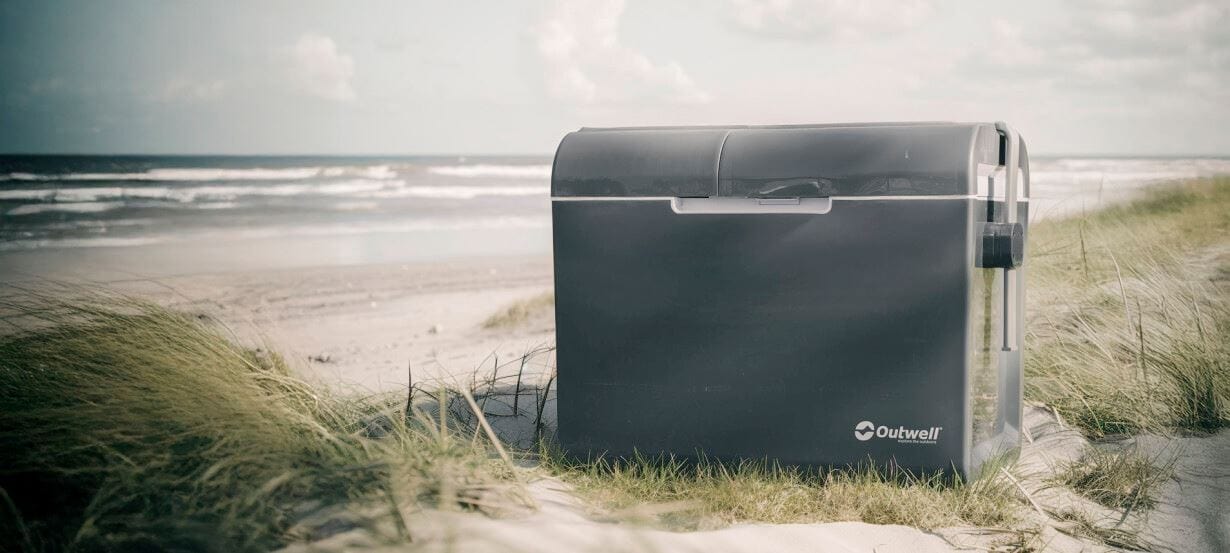 Outwell ECOcool 35 Litre Coolbox - 12 Volt & 230 Volt Dual Power - lifestyle image of product shown outdoors