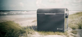 Outwell ECOcool 35 Litre Coolbox - 12 Volt & 230 Volt Dual Power - lifestyle image of product shown outdoors