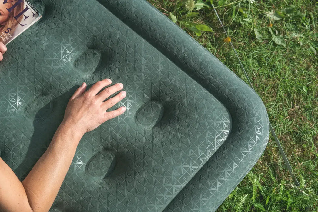 Outwell Excellent Single Camping Airbed - lifestyle image, showing close-up of airbed outside on grass with person's arm visible on top