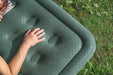 Outwell Excellent Single Camping Airbed - lifestyle image, showing close-up of airbed outside on grass with person's arm visible on top