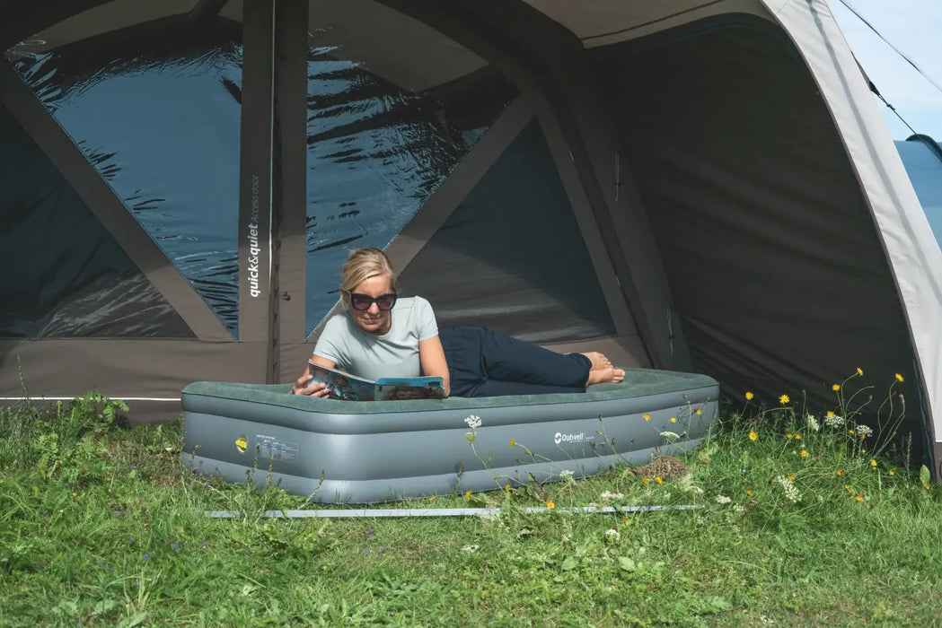 Outwell Excellent Single Camping Airbed - lifestyle image, showing person lying on mattress in tent entrance doorway