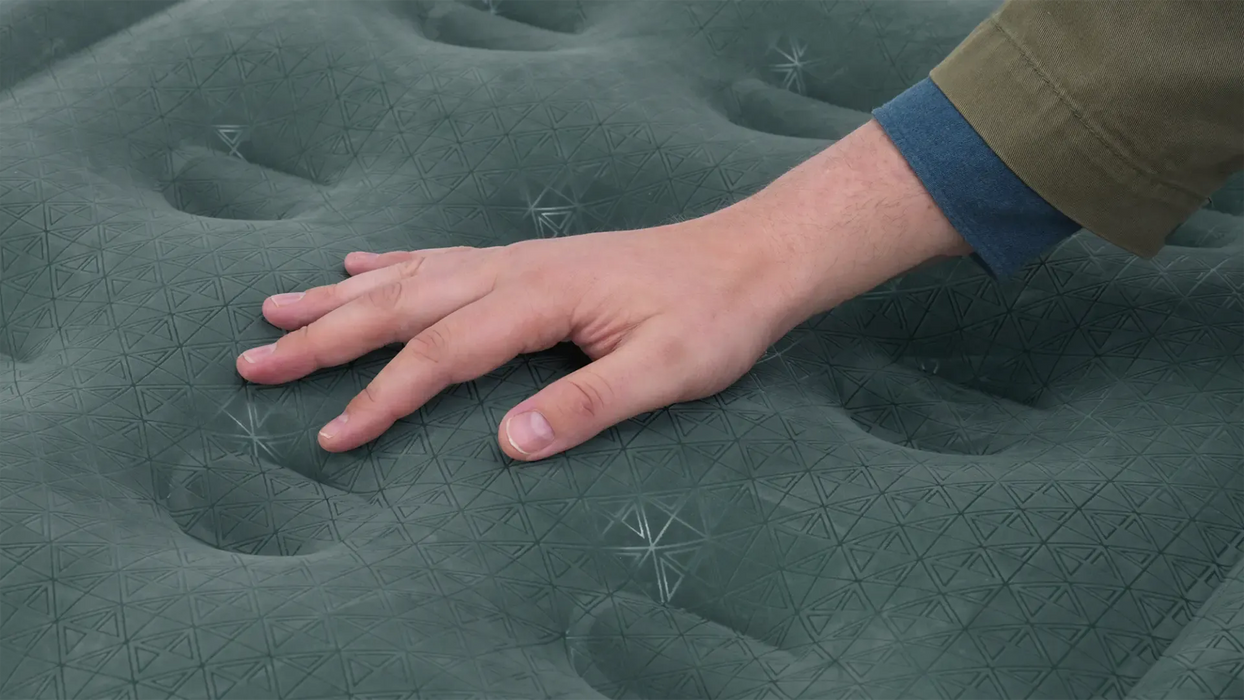 Outwell Excellent Single Camping Airbed - product image, showing close-up of top layer material with person's hand