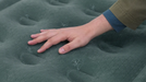 Outwell Excellent Single Camping Airbed - product image, showing close-up of top layer material with person's hand