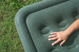 Outwell Flock Excellent King Size Inflatable Camping Mattress - lifestyle image, showing mattress outside on grass with person's hand in frame