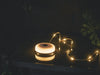Outwell Moonstone String Light Camping Lantern - lifestyle image, showing light and string lights around plant pot