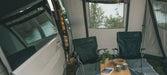 Outwell Moonstone String Light Camping Lantern - lifestyle image, showing string light inside vehicle door with awning and chairs