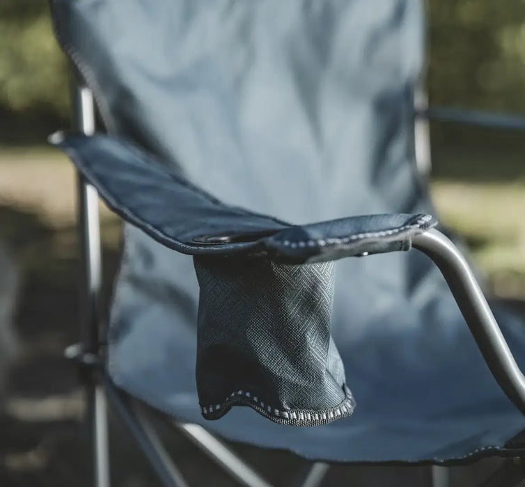 Outwell Spruce Folding Camping Chair - Fjord Blue - lifestyle image, showing chair outdoors, with close-up on armrest drinks holder